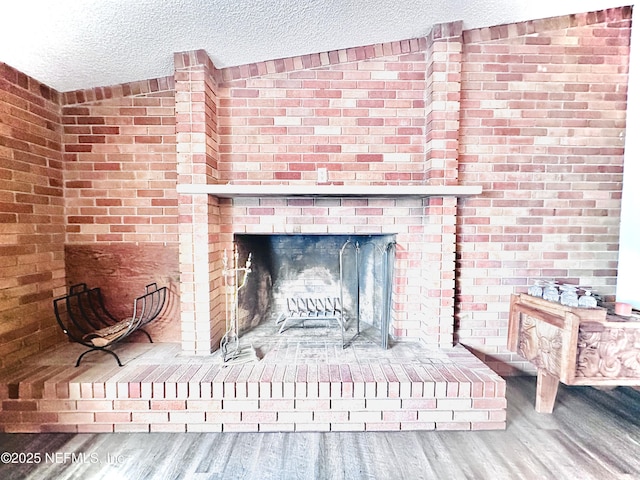 room details with wood-type flooring, a fireplace, and a textured ceiling