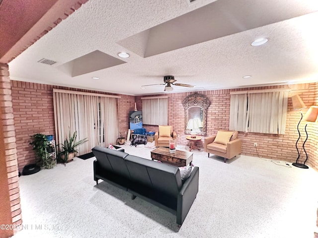 carpeted living room with brick wall, a wood stove, a textured ceiling, and ceiling fan