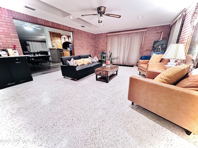 living room with ceiling fan and brick wall