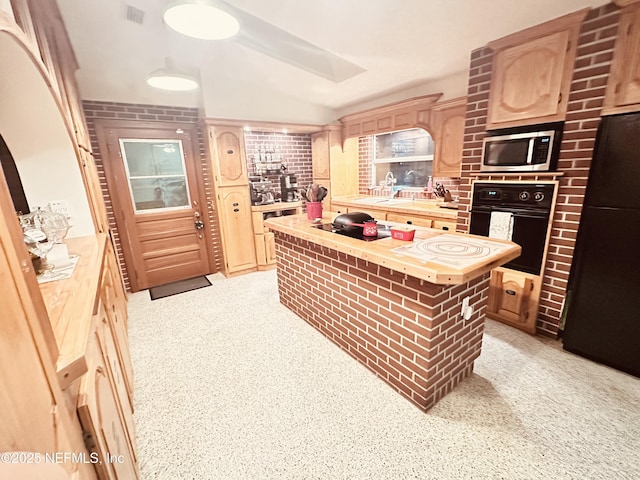 kitchen featuring butcher block counters, light brown cabinetry, a kitchen island, and black appliances