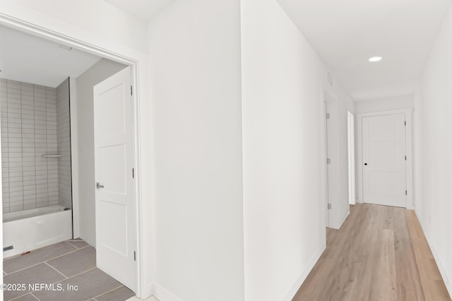 hall with light wood-style floors, recessed lighting, and baseboards