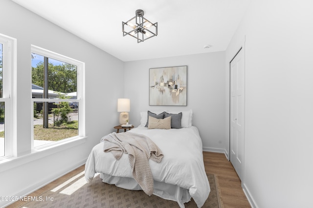 420 Herbert St, Saint Augustine, FL 32084 - bedroom with baseboards, a notable chandelier, wood finished floors, and a closet