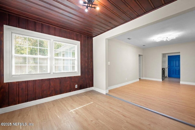 unfurnished room with wood ceiling, hardwood / wood-style floors, and wood walls