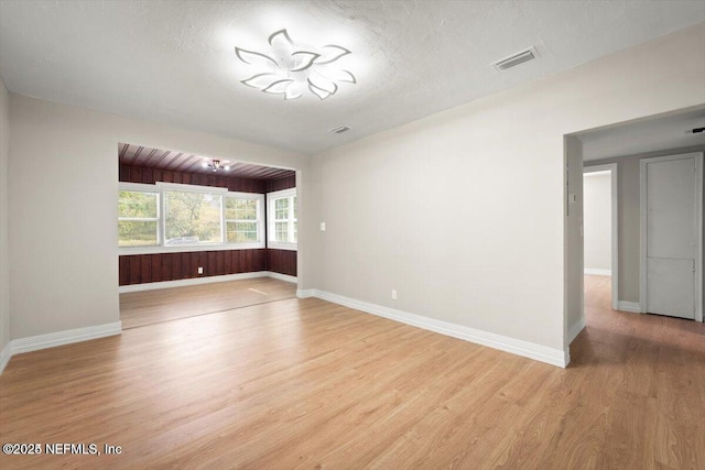 unfurnished room featuring a textured ceiling and light wood-type flooring