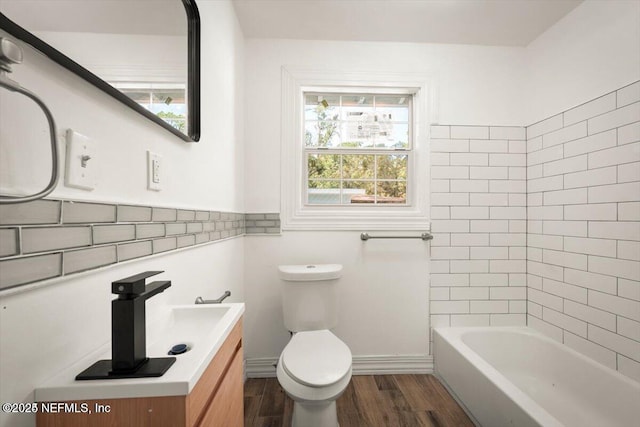 bathroom with vanity, a bathtub, wood-type flooring, and toilet