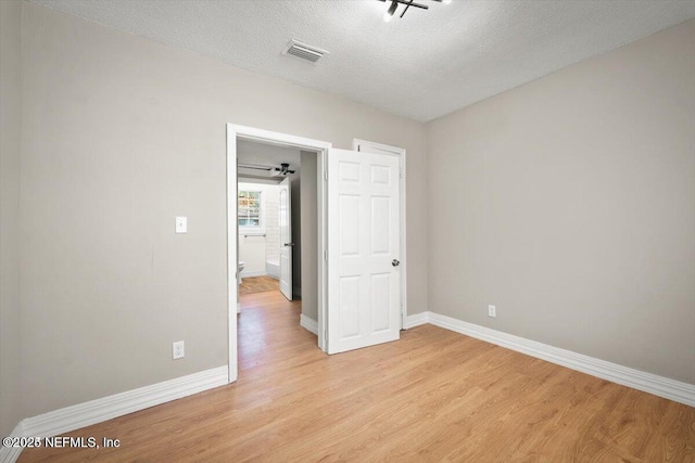 unfurnished bedroom featuring a textured ceiling and light wood-type flooring