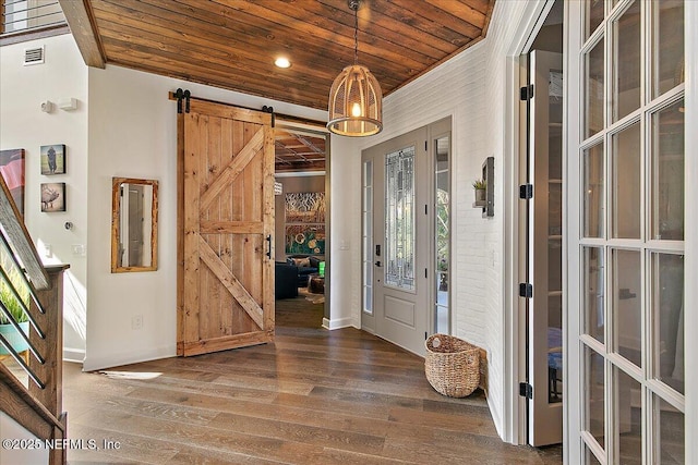 foyer entrance with wood ceiling, a barn door, and dark hardwood / wood-style flooring