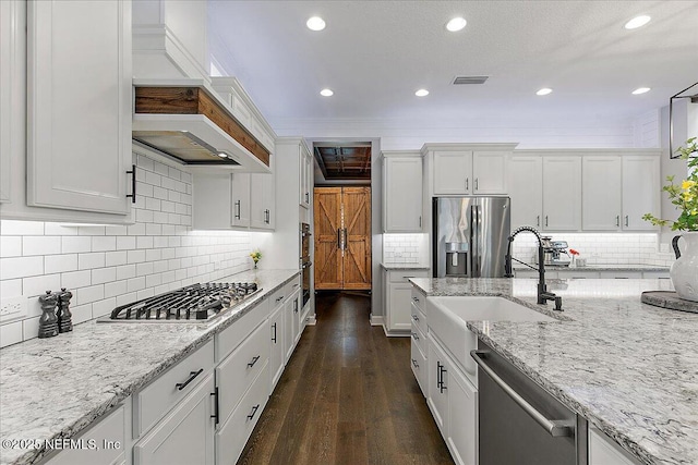 kitchen with sink, stainless steel appliances, white cabinets, and light stone countertops