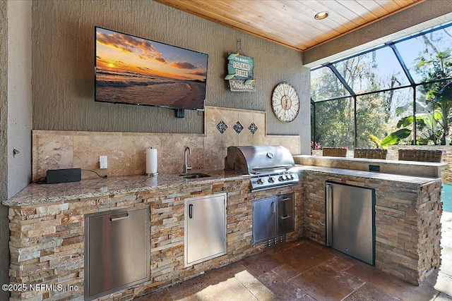 view of patio featuring area for grilling, a lanai, exterior kitchen, and sink