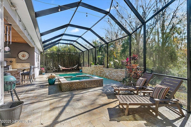 view of patio with a lanai and a pool with hot tub