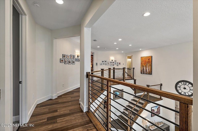 corridor featuring dark hardwood / wood-style flooring and a textured ceiling