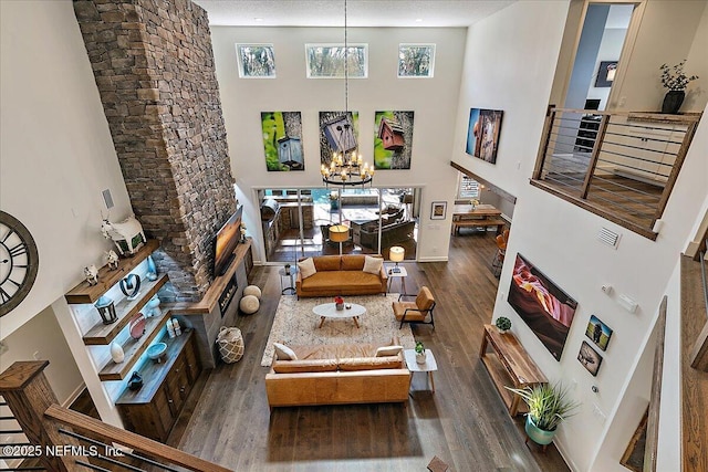 living room with wood-type flooring, a towering ceiling, and a notable chandelier