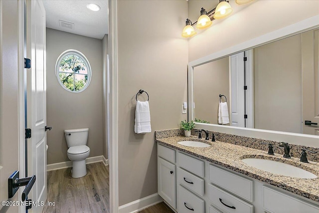 bathroom featuring vanity, a textured ceiling, wood-type flooring, and toilet