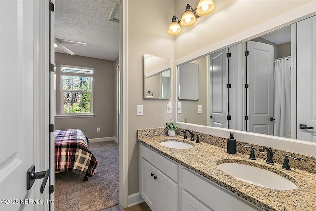 bathroom featuring ceiling fan, vanity, and a textured ceiling