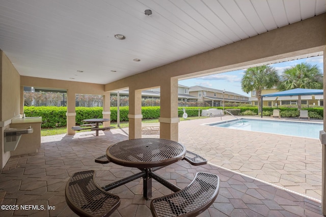 view of patio / terrace featuring fence, a fire pit, and an outdoor pool