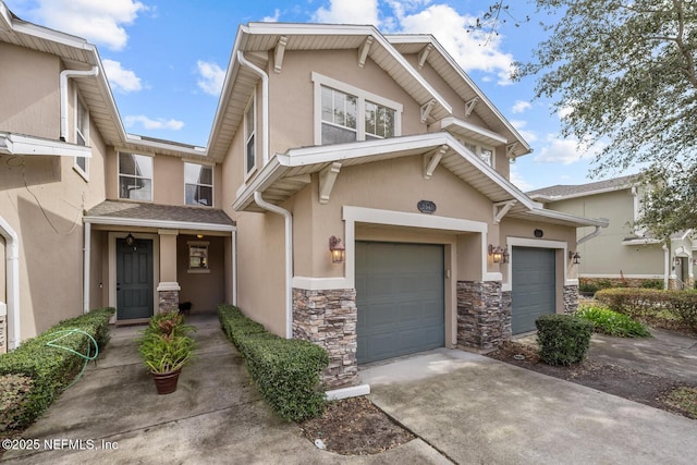 view of property featuring a garage, stone siding, concrete driveway, and stucco siding