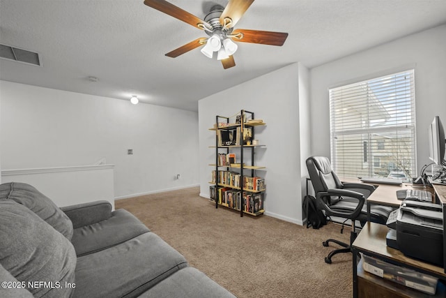 office space featuring ceiling fan, visible vents, a textured ceiling, and light colored carpet