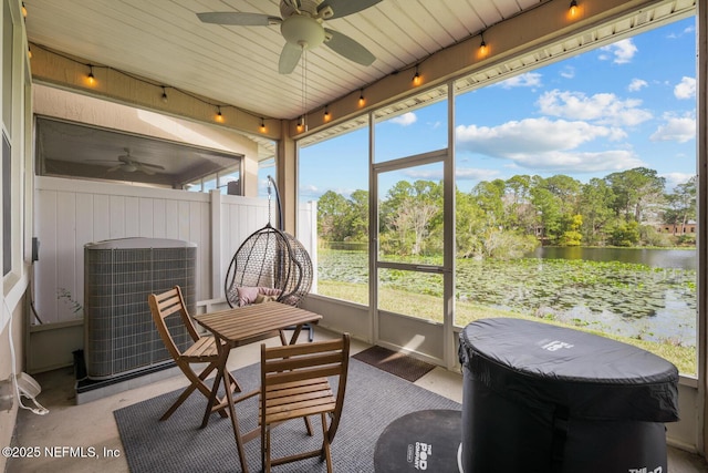 sunroom / solarium with a water view and a ceiling fan