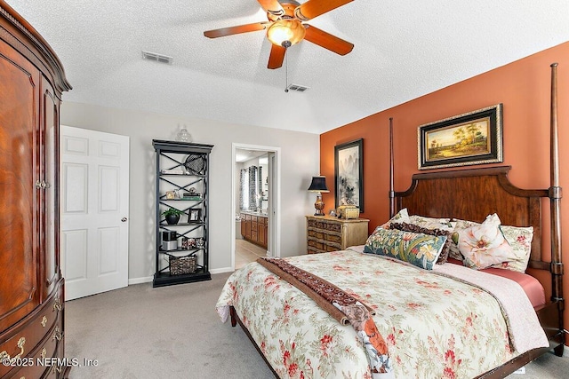 carpeted bedroom with ceiling fan, ensuite bathroom, and a textured ceiling