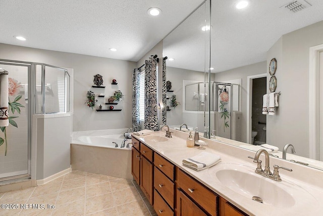 full bathroom with separate shower and tub, vanity, a textured ceiling, tile patterned floors, and toilet