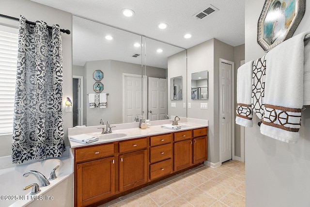 bathroom featuring vanity, tile patterned flooring, and a tub