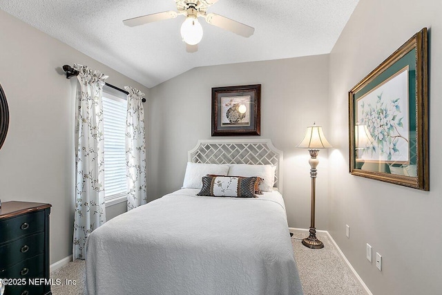 carpeted bedroom featuring ceiling fan, vaulted ceiling, and a textured ceiling