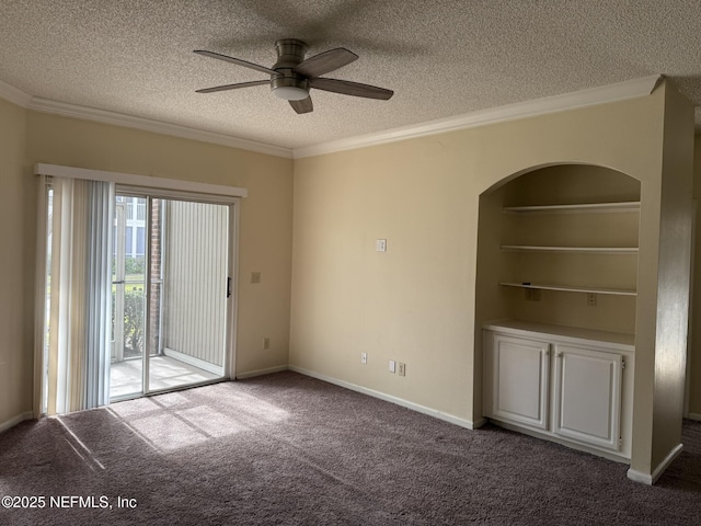 carpeted spare room featuring ceiling fan, ornamental molding, a textured ceiling, and built in features