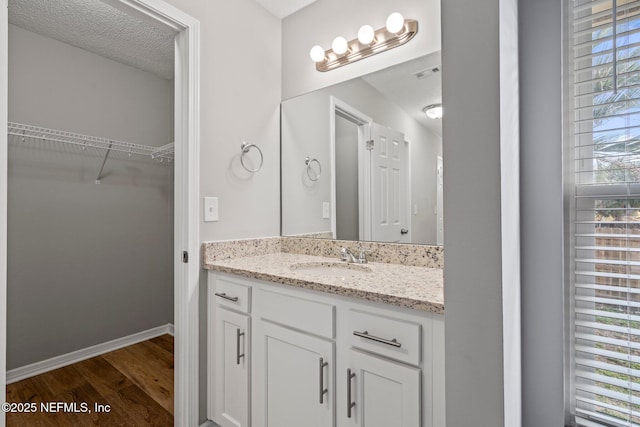 bathroom featuring vanity, hardwood / wood-style flooring, and a textured ceiling