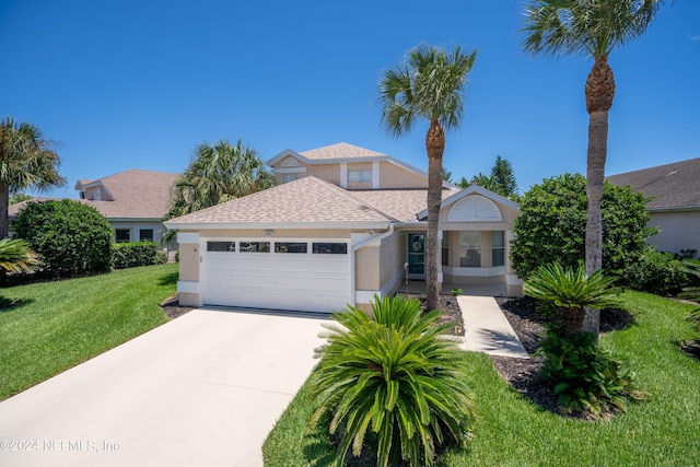 view of front of property featuring a garage and a front lawn