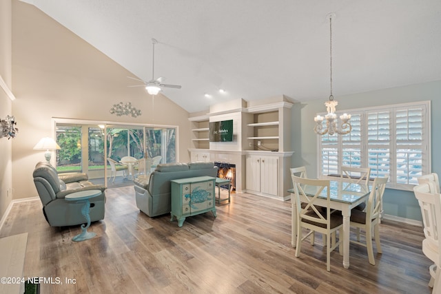 living room with hardwood / wood-style flooring, ceiling fan with notable chandelier, and high vaulted ceiling