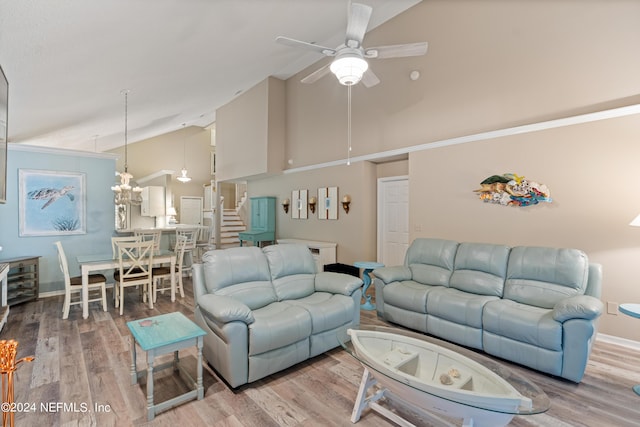 living room featuring wood-type flooring, ceiling fan with notable chandelier, and high vaulted ceiling