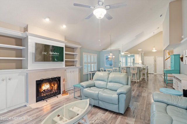 living room featuring light hardwood / wood-style flooring, a high end fireplace, vaulted ceiling, and ceiling fan