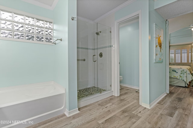 bathroom with ornamental molding, wood-type flooring, independent shower and bath, and a textured ceiling