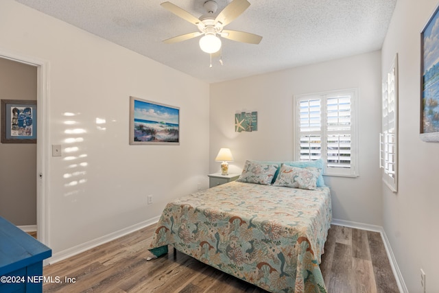 bedroom featuring hardwood / wood-style flooring, ceiling fan, and a textured ceiling