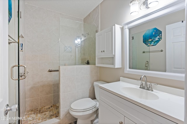 bathroom with walk in shower, vanity, a textured ceiling, and toilet