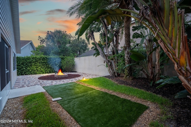 yard at dusk featuring an outdoor fire pit