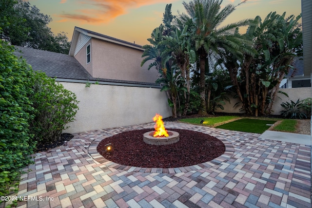 patio terrace at dusk featuring a fire pit