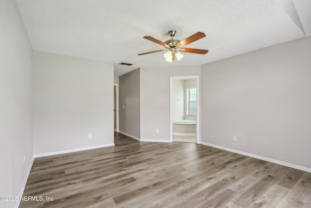 unfurnished room featuring ceiling fan, hardwood / wood-style floors, and a textured ceiling