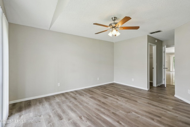 spare room featuring ceiling fan, hardwood / wood-style floors, and a textured ceiling