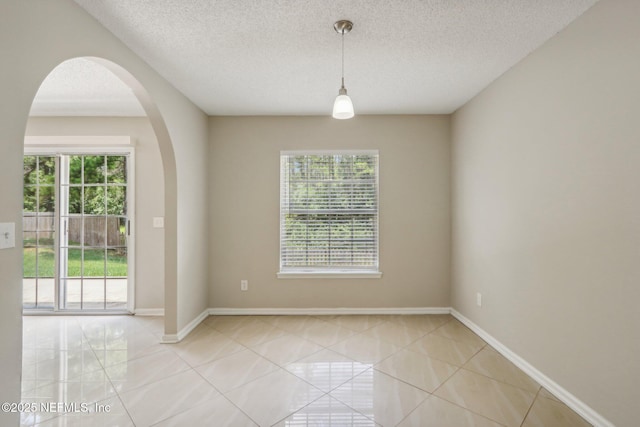 unfurnished room featuring a textured ceiling and light tile patterned floors