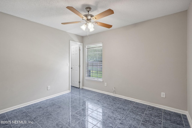 unfurnished room with ceiling fan and a textured ceiling