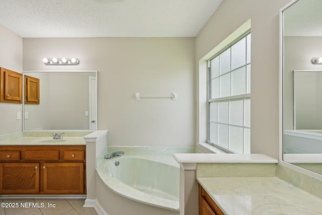 bathroom with vanity, a bathing tub, tile patterned flooring, and a textured ceiling