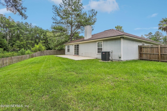 back of house with central AC unit, a lawn, and a patio area