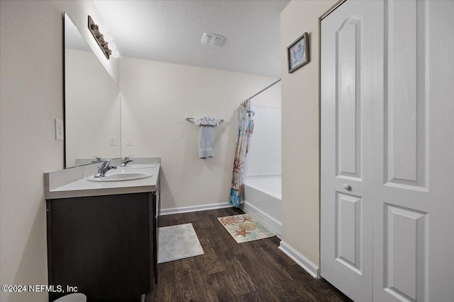 bathroom with vanity, a textured ceiling, wood-type flooring, and shower / bath combo