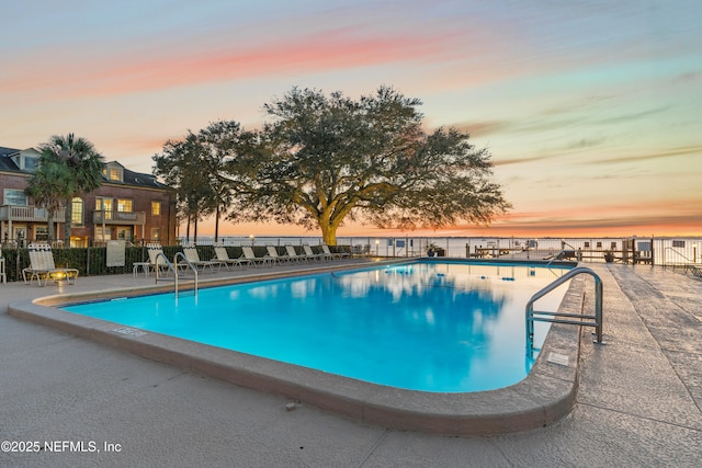 pool at dusk featuring a patio area