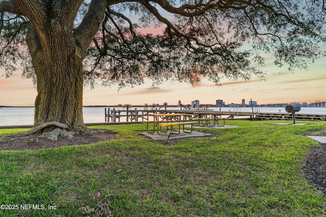 view of community with a water view and a lawn