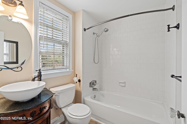 full bathroom featuring vanity, tiled shower / bath, and toilet