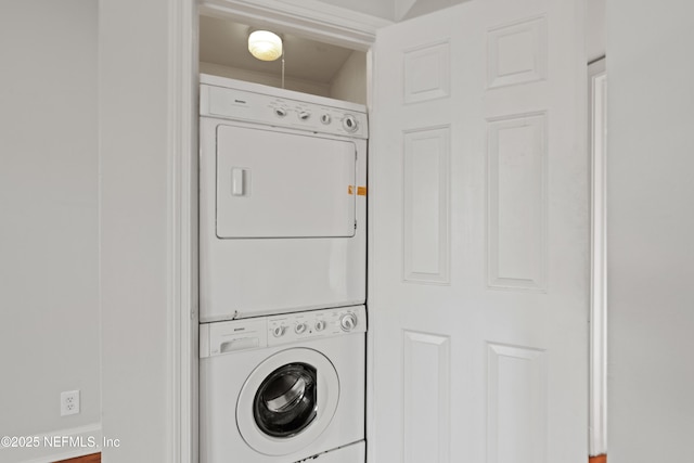 washroom featuring stacked washer and clothes dryer