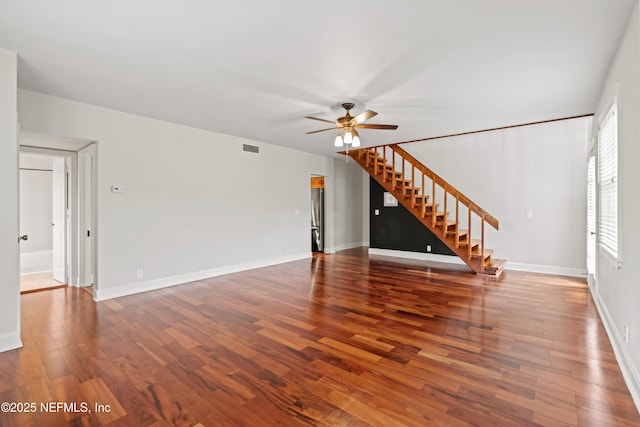 unfurnished living room featuring ceiling fan and dark hardwood / wood-style floors