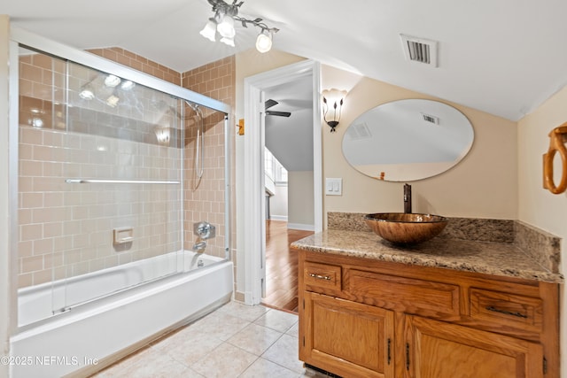 bathroom featuring tile patterned flooring, vanity, and enclosed tub / shower combo